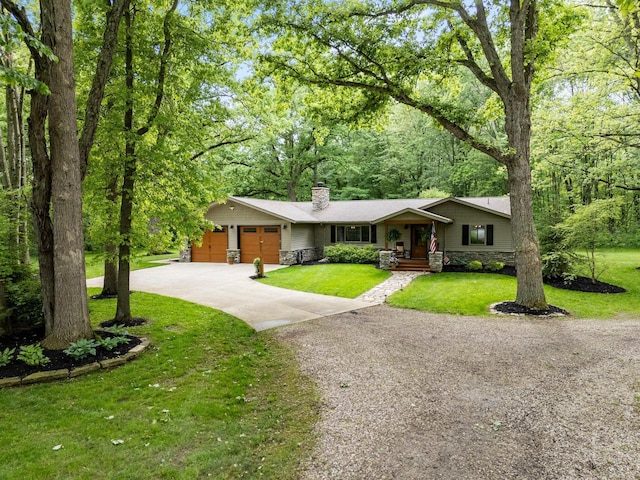 429 N Old State Rd, Delaware, OH 43015 - view of front of property featuring a chimney, an attached garage, driveway, stone siding, and a front lawn