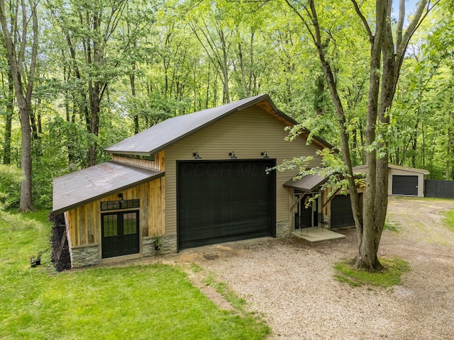 429 N Old State Rd, Delaware, OH 43015 - view of front of home with stone siding, french doors, driveway, metal roof, and an outdoor structure
