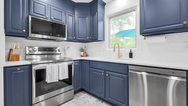 11600 Windridge Dr NW, Pickerington, OH 43147 - kitchen with stainless steel appliances, a sink, blue cabinets, and backsplash