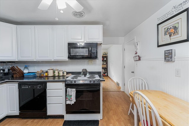 2747 Castlewood Rd, Columbus, OH 43209 - kitchen with black appliances, light wood-style floors, white cabinets, dark countertops, and ceiling fan
