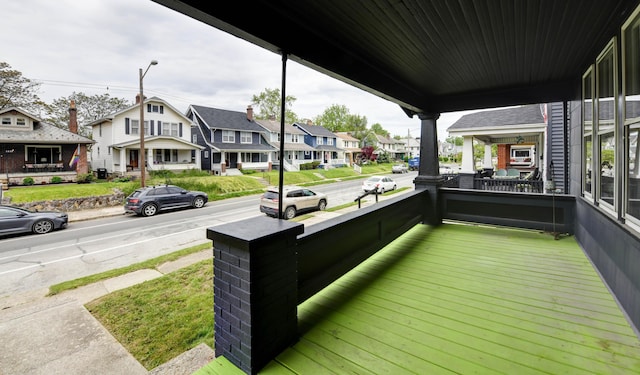wooden deck with a residential view and a porch