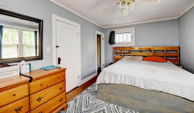bedroom featuring crown molding, dark wood-type flooring, baseboards, and ceiling fan