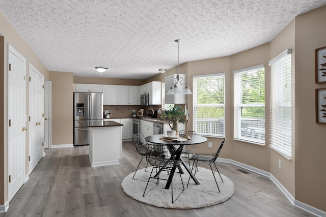 6289 Corley Dr, Dublin, OH 43016 - dining room with light wood finished floors, baseboards, and a textured ceiling