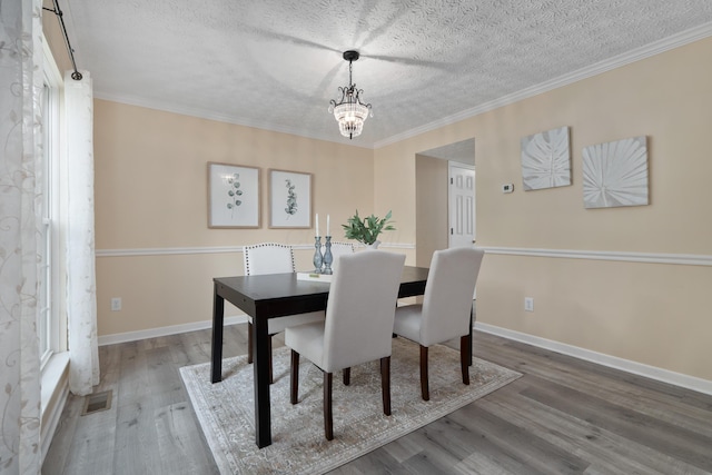 6289 Corley Dr, Dublin, OH 43016 - dining area with a chandelier, a textured ceiling, wood finished floors, baseboards, and ornamental molding