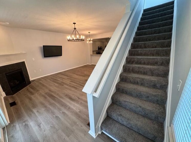 4020 Legend Unit 11, Columbus, OH 43230 - staircase with wood finished floors, a fireplace with flush hearth, a chandelier, and baseboards