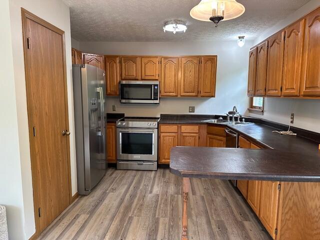 50 Stagecoach Rd, Chillicothe, OH 45601 - kitchen with appliances with stainless steel finishes, dark countertops, a sink, a peninsula, and brown cabinets