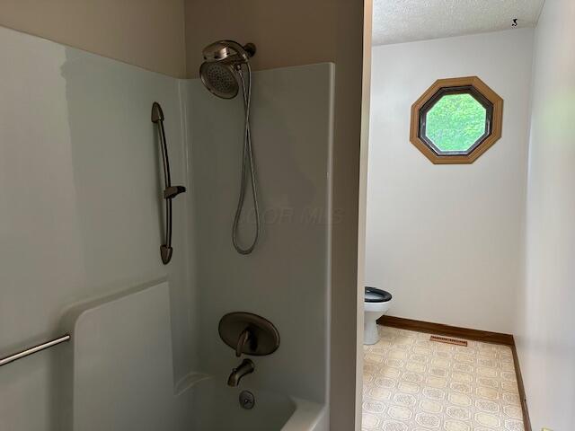 50 Stagecoach Rd, Chillicothe, OH 45601 - full bath featuring toilet, baseboards, bathing tub / shower combination, and a textured ceiling
