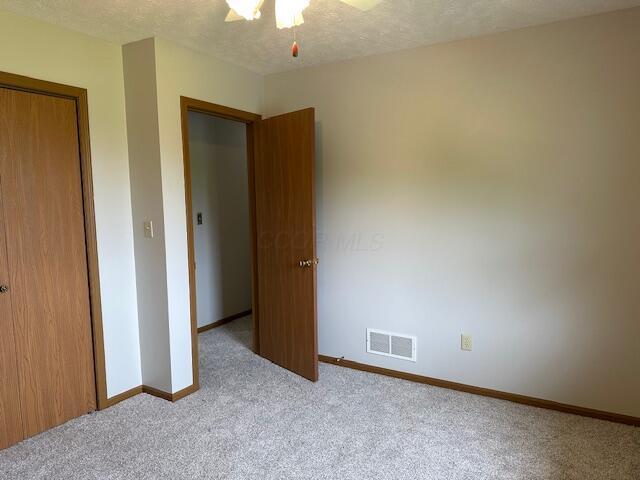 50 Stagecoach Rd, Chillicothe, OH 45601 - unfurnished bedroom with carpet floors, baseboards, a closet, a textured ceiling, and ceiling fan