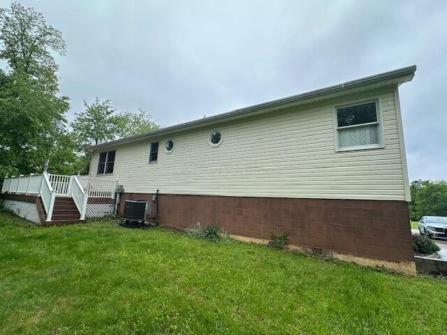 50 Stagecoach Rd, Chillicothe, OH 45601 - rear view of property featuring a deck, a lawn, and central AC
