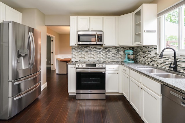 1671 Dollivor Dr, Columbus, OH 43235 - kitchen with appliances with stainless steel finishes, a sink, dark wood finished floors, and white cabinetry
