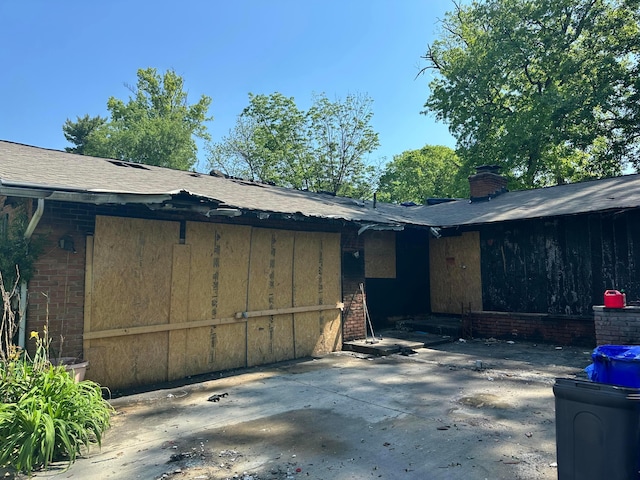 1294 Lancelot Rd, Columbus, OH 43227 - view of property exterior featuring brick siding, a patio area, a chimney, and roof with shingles