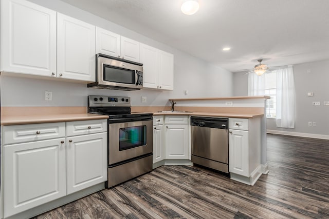 5962 Thunder Gulch Dr, New Albany, OH 43054 - kitchen featuring stainless steel appliances, a sink, a peninsula, dark wood finished floors, and light countertops
