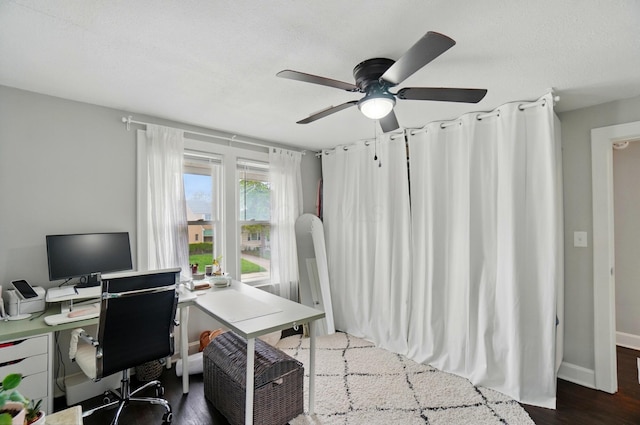 office area with a ceiling fan, dark wood finished floors, and baseboards