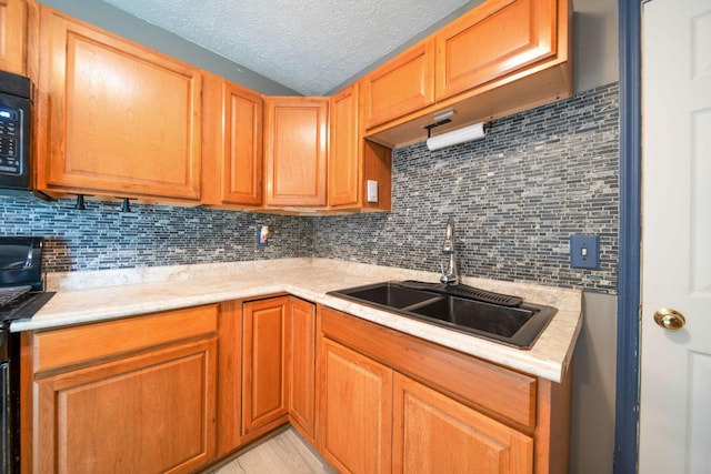 3233 Burdett Ct, Columbus, OH 43232 - kitchen featuring a sink, light countertops, decorative backsplash, a textured ceiling, and light wood-type flooring
