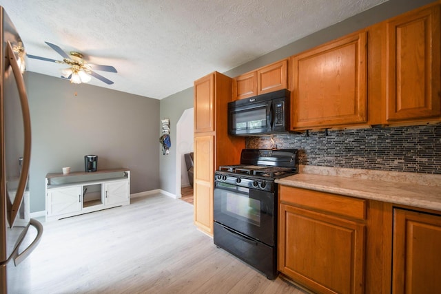 3233 Burdett Ct, Columbus, OH 43232 - kitchen with black appliances, ceiling fan, light wood finished floors, tasteful backsplash, and brown cabinetry