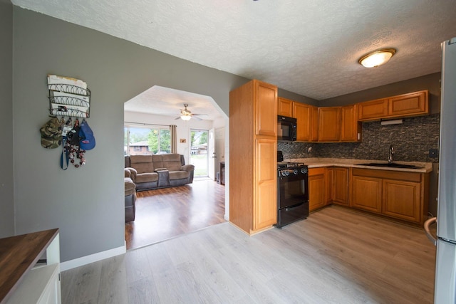 3233 Burdett Ct, Columbus, OH 43232 - kitchen featuring black appliances, a sink, light wood-style floors, a textured ceiling, and backsplash