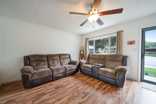 3233 Burdett Ct, Columbus, OH 43232 - living room featuring light wood-type flooring, a textured ceiling, ceiling fan, and baseboards