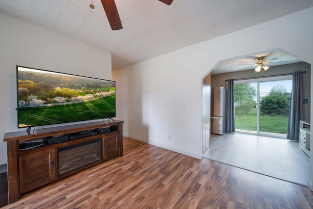 3233 Burdett Ct, Columbus, OH 43232 - unfurnished living room with a ceiling fan, light wood-type flooring, baseboards, and a textured ceiling