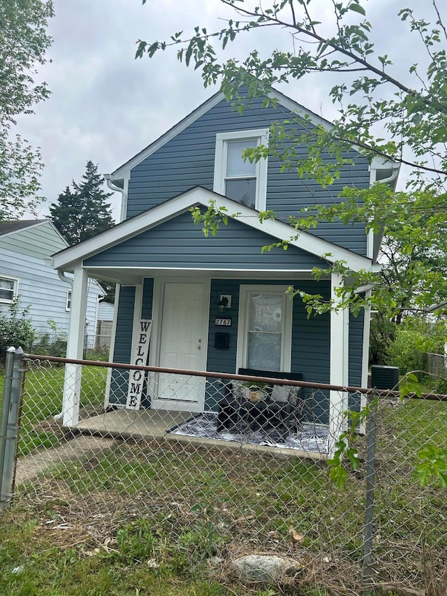 shotgun-style home featuring a porch, fence, and central AC
