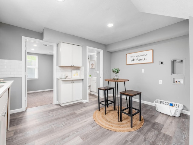 2767 Hiawatha St, Columbus, OH 43211 - kitchen featuring white cabinets, decorative backsplash, light wood-type flooring, and recessed lighting