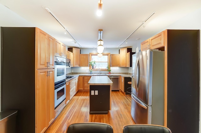 789 Chelsea Ave, Columbus, OH 43209 - kitchen featuring stainless steel appliances, track lighting, light countertops, a kitchen island, and light wood-style flooring
