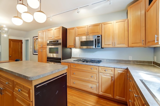 789 Chelsea Ave, Columbus, OH 43209 - kitchen with appliances with stainless steel finishes, track lighting, a center island, light wood finished floors, and a sink