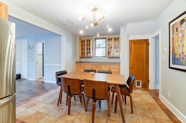 789 Chelsea Ave, Columbus, OH 43209 - dining room with a chandelier, light tile patterned floors, and baseboards