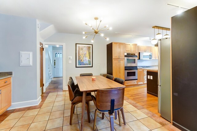 789 Chelsea Ave, Columbus, OH 43209 - dining space with light tile patterned floors, a chandelier, track lighting, and baseboards