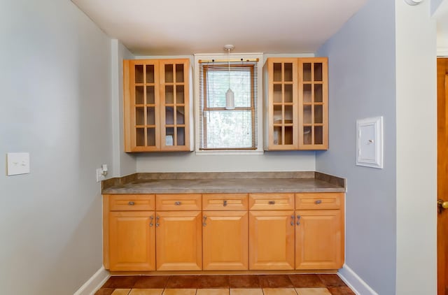 789 Chelsea Ave, Columbus, OH 43209 - kitchen featuring baseboards, glass insert cabinets, and light tile patterned floors