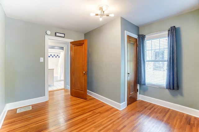 789 Chelsea Ave, Columbus, OH 43209 - unfurnished bedroom with light wood-type flooring, baseboards, a closet, and a chandelier
