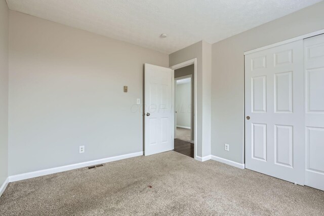 unfurnished bedroom with carpet flooring, baseboards, and a closet