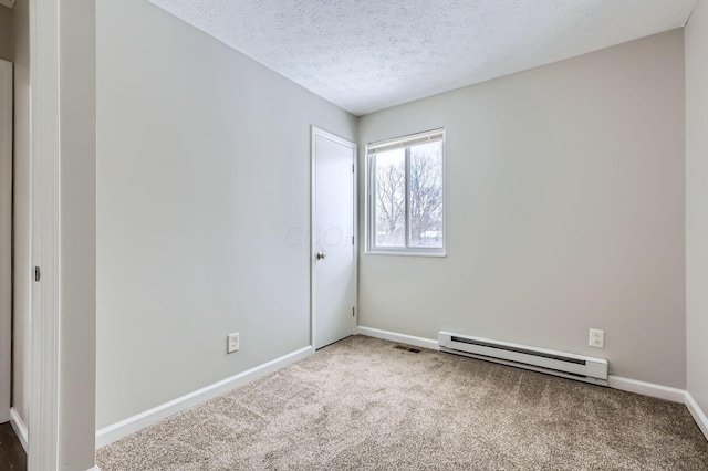 carpeted spare room with baseboard heating, baseboards, and a textured ceiling
