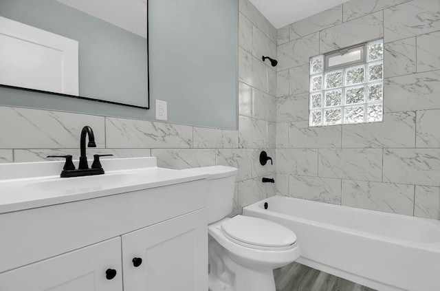 full bath featuring vanity, toilet, bathing tub / shower combination, tile walls, and wood finished floors