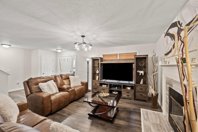 1608 Geranium Dr, Lewis Center, OH 43035 - living room with a tiled fireplace, a chandelier, a textured ceiling, baseboards, and dark wood-style flooring