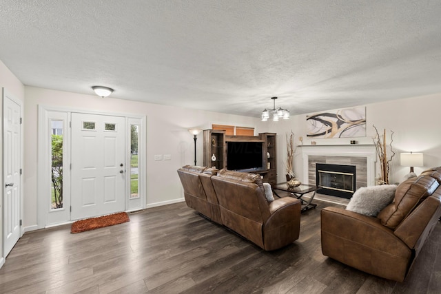 1608 Geranium Dr, Lewis Center, OH 43035 - living room with dark wood-style flooring, a chandelier, a textured ceiling, a tile fireplace, and baseboards