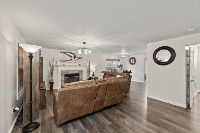1608 Geranium Dr, Lewis Center, OH 43035 - living area with dark wood-style flooring, baseboards, a tile fireplace, and a chandelier