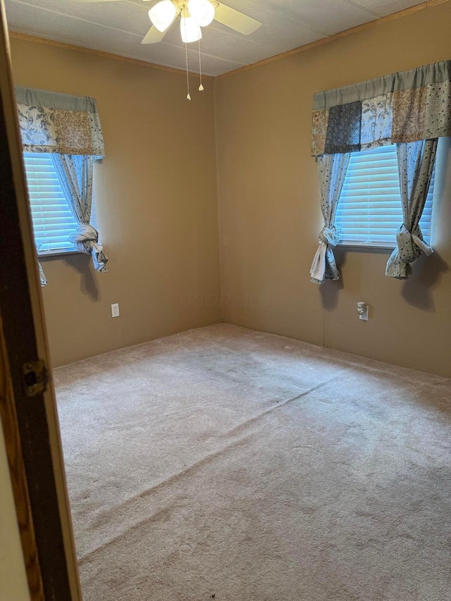 carpeted empty room with a ceiling fan
