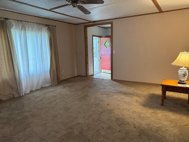 carpeted empty room with a ceiling fan and baseboards