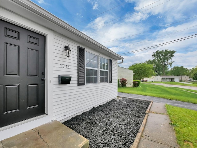 entrance to property featuring a lawn