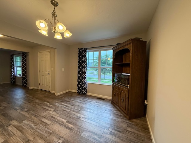 210 Glemsbury Dr, Delaware, OH 43015 - unfurnished dining area featuring a chandelier, dark wood finished floors, and baseboards