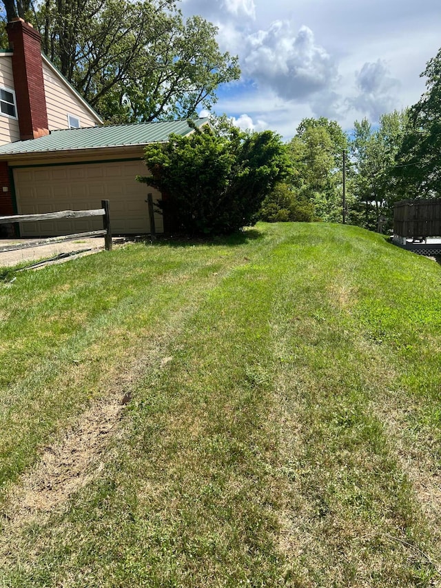 view of green lawn with an attached garage