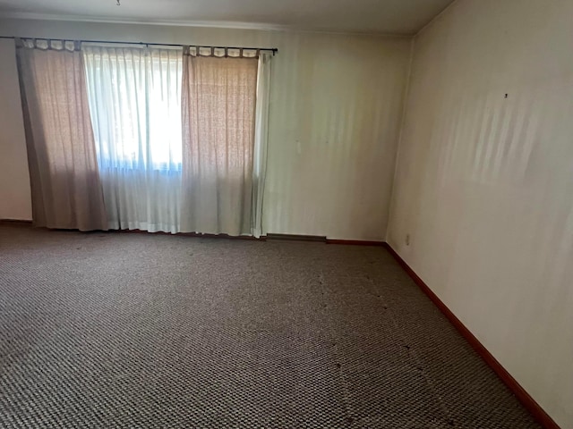 unfurnished room with carpet floors and baseboards