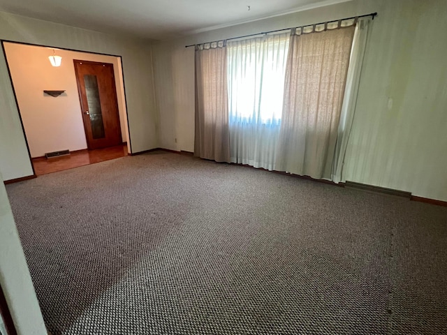 carpeted spare room featuring baseboards