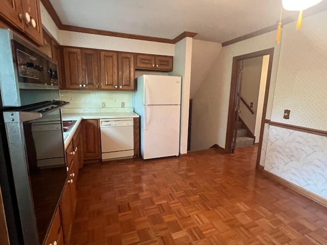 kitchen featuring white appliances, wallpapered walls, light countertops, baseboards, and crown molding