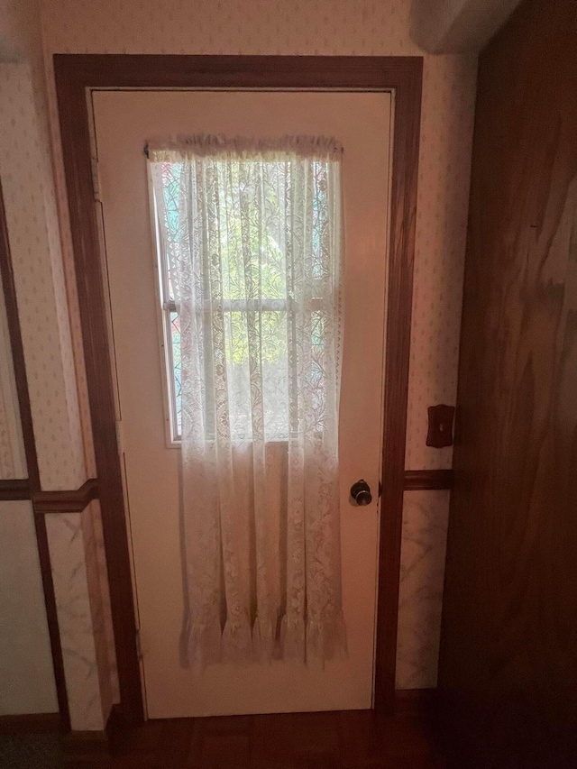 doorway to outside with wallpapered walls
