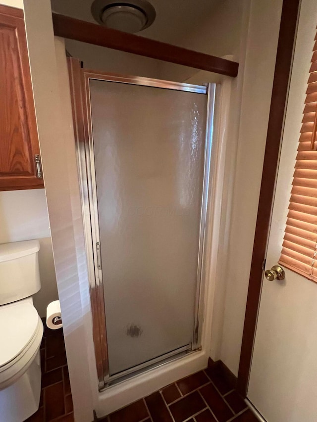 bathroom with a stall shower and toilet