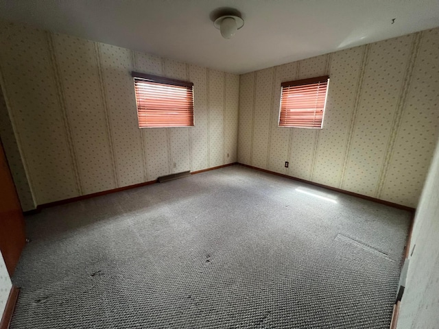 carpeted spare room with wallpapered walls