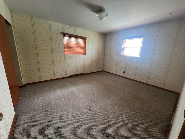 unfurnished room featuring carpet floors and wallpapered walls