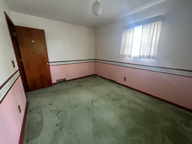 empty room featuring carpet flooring and baseboards