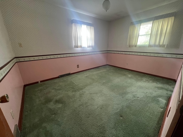 unfurnished room featuring carpet floors, baseboards, and wallpapered walls